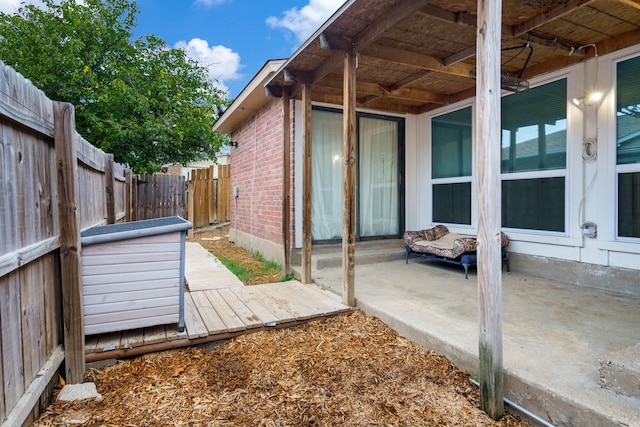 view of side of home featuring a wooden deck and a patio area