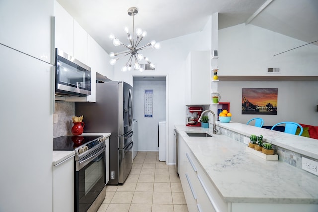 kitchen with white cabinets, stainless steel appliances, lofted ceiling, and sink