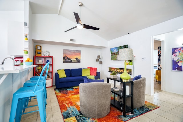 living room featuring lofted ceiling, sink, light tile patterned floors, and ceiling fan