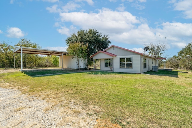 rear view of property featuring central AC, a lawn, and a storage unit