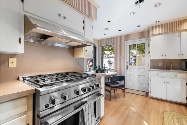 kitchen with high end stainless steel range, light hardwood / wood-style floors, and white cabinets