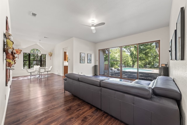 living room featuring dark hardwood / wood-style flooring, lofted ceiling, and ceiling fan