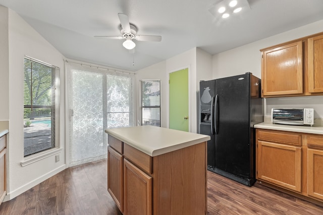 kitchen featuring vaulted ceiling, dark hardwood / wood-style floors, ceiling fan, a kitchen island, and black refrigerator with ice dispenser