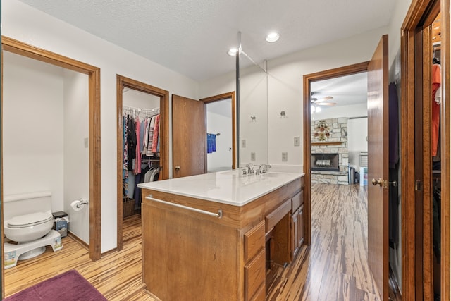 bathroom featuring a stone fireplace, a textured ceiling, and hardwood / wood-style flooring