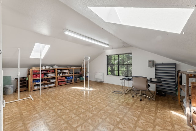 office space with a textured ceiling and lofted ceiling with skylight