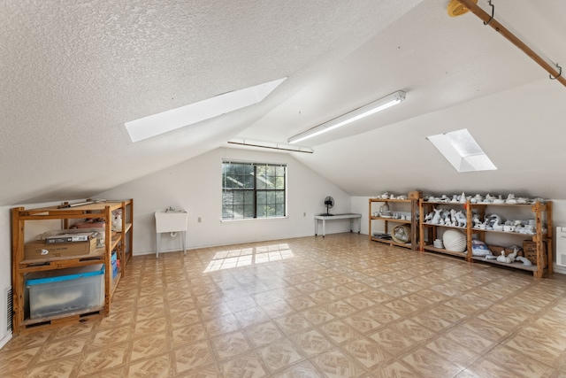 additional living space featuring vaulted ceiling and a textured ceiling