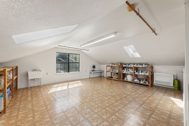 bonus room with a textured ceiling and lofted ceiling with skylight