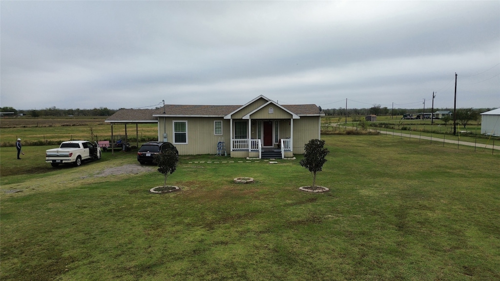 view of front of home featuring a front lawn, covered porch, and a carport