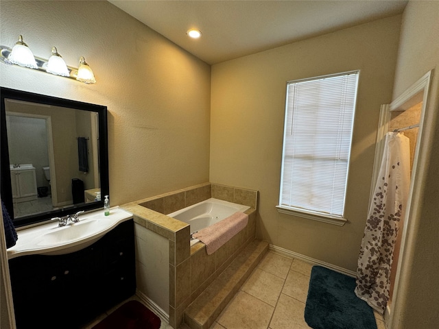 bathroom featuring tile patterned flooring, vanity, and a relaxing tiled tub