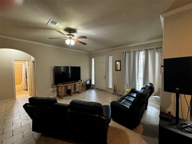 tiled living room with ceiling fan, a textured ceiling, and crown molding