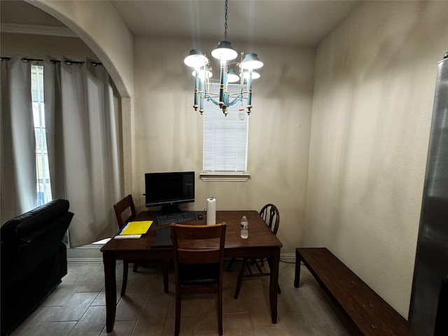 tiled dining area featuring a chandelier and ornamental molding