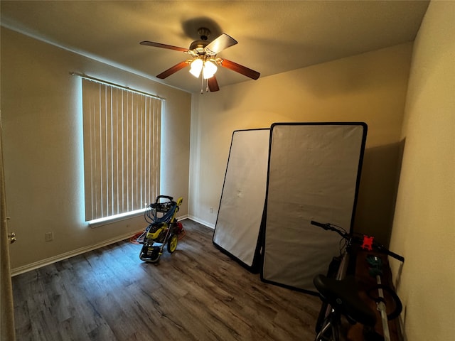 workout room with dark wood-type flooring and ceiling fan