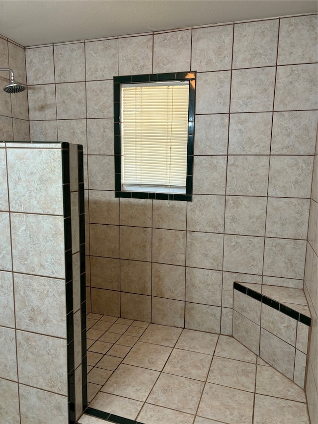 bathroom with tile patterned flooring and tiled shower