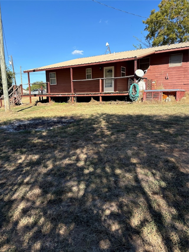 rear view of house with a yard and a deck