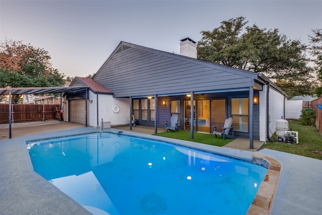 pool at dusk with a patio