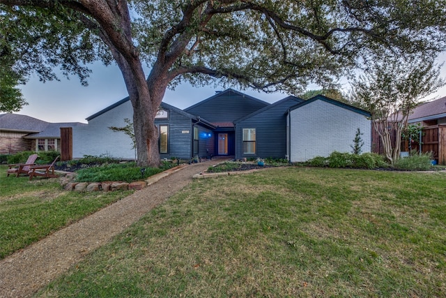 ranch-style home featuring a front lawn