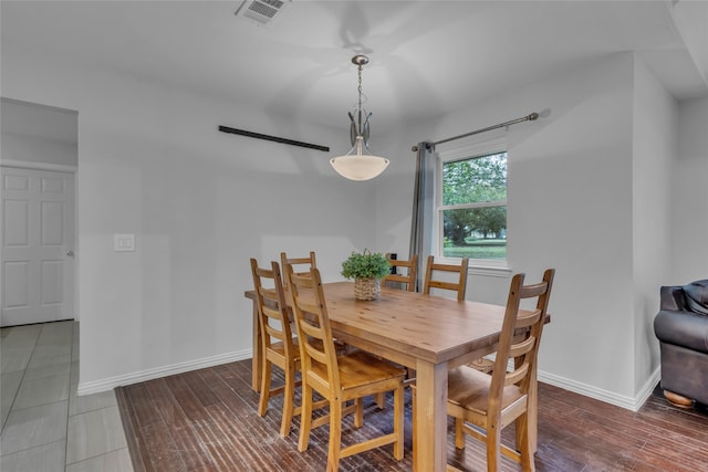 dining room with baseboards, visible vents, and wood finished floors