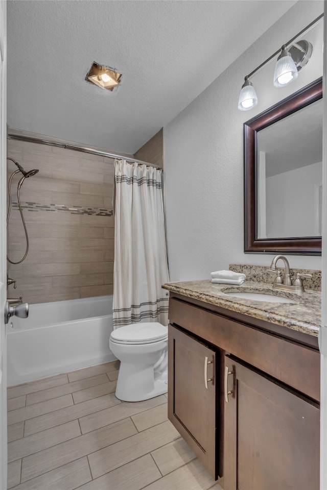 bathroom with toilet, vanity, a textured ceiling, wood finish floors, and shower / bath combination with curtain