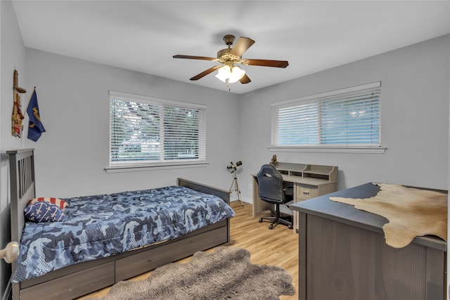 bedroom with light hardwood / wood-style floors and ceiling fan