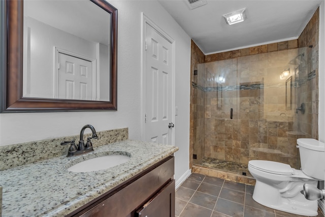 bathroom featuring tile patterned flooring, vanity, toilet, and a shower with door