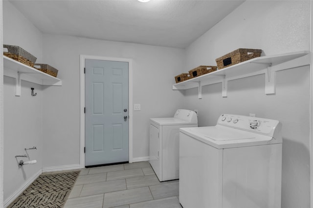 laundry area with laundry area, baseboards, and separate washer and dryer