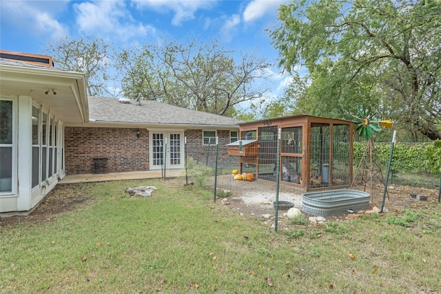 view of yard featuring a sunroom and french doors