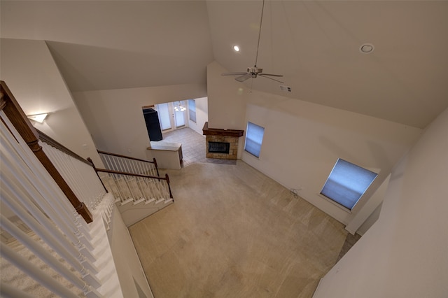 living room with high vaulted ceiling, carpet, ceiling fan, and a fireplace