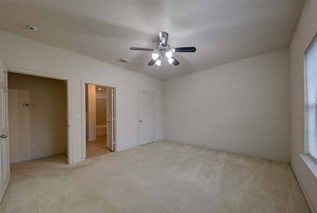 unfurnished bedroom with ceiling fan, connected bathroom, and light carpet