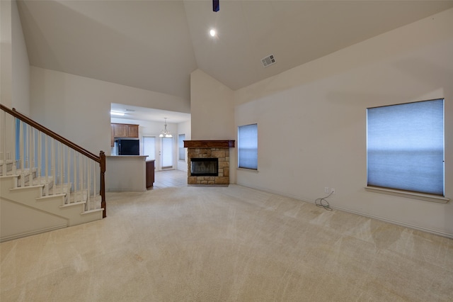 unfurnished living room with light colored carpet, a stone fireplace, and high vaulted ceiling