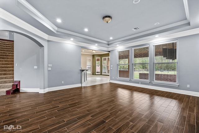 unfurnished living room with dark hardwood / wood-style flooring, crown molding, and a tray ceiling