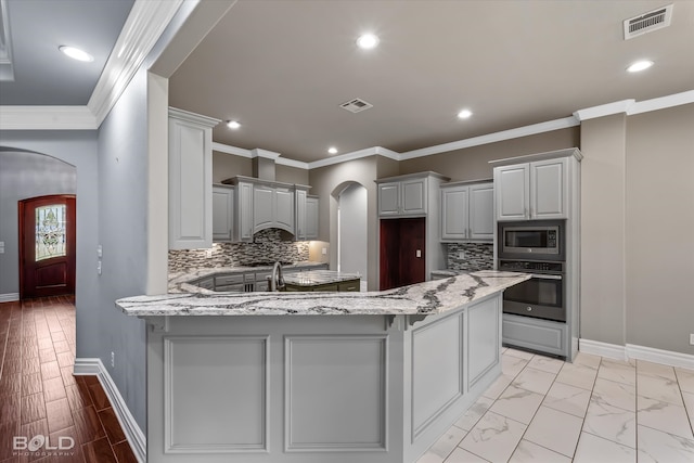 kitchen featuring stainless steel appliances, gray cabinets, and ornamental molding