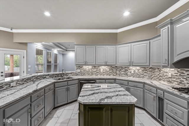 kitchen with ornamental molding, a kitchen island, backsplash, gray cabinets, and sink