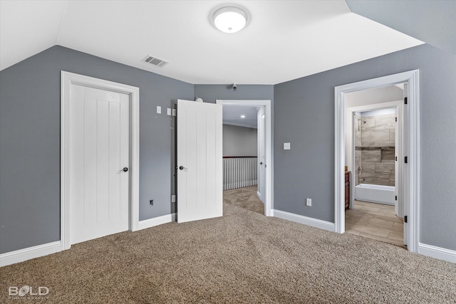 unfurnished bedroom featuring light colored carpet and lofted ceiling