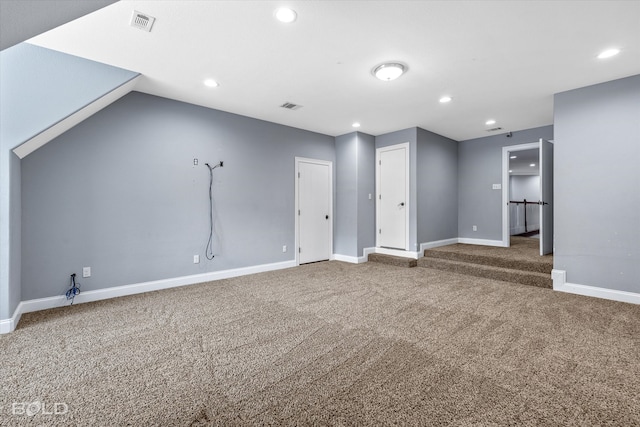 unfurnished living room with vaulted ceiling and carpet flooring