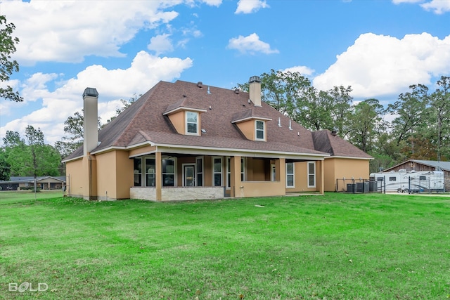 back of property with cooling unit and a lawn