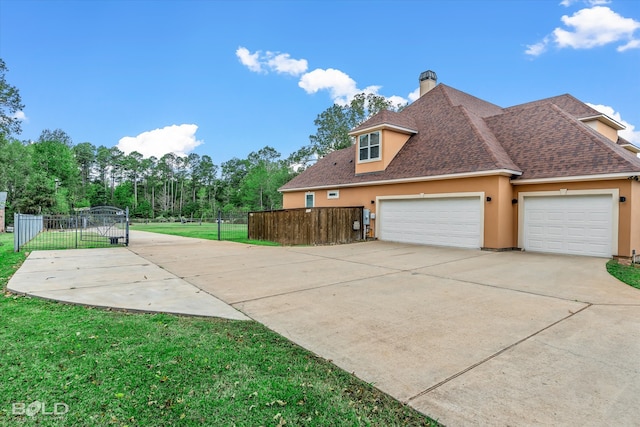 view of side of home featuring a garage and a yard