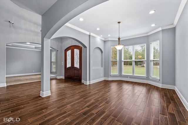 foyer entrance with ornamental molding and dark hardwood / wood-style floors