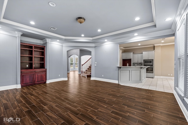 unfurnished living room featuring crown molding and dark hardwood / wood-style flooring