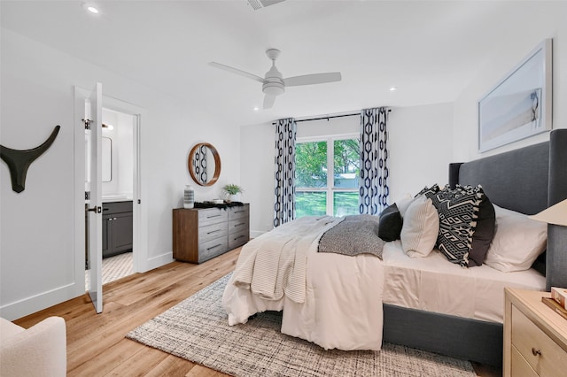 bedroom with ceiling fan, connected bathroom, and light hardwood / wood-style flooring