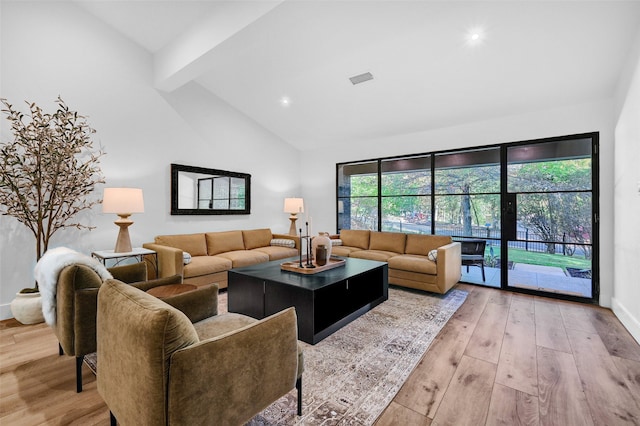 living room with beam ceiling, light hardwood / wood-style flooring, and high vaulted ceiling