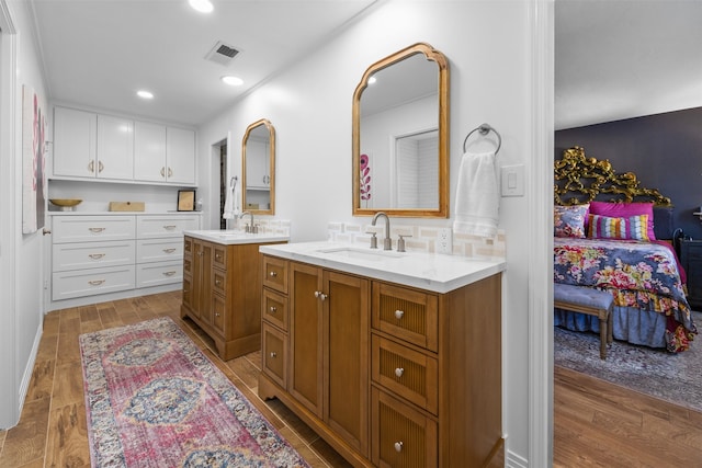 bathroom featuring hardwood / wood-style flooring, vanity, and decorative backsplash