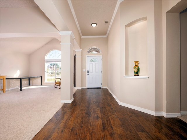 foyer entrance featuring decorative columns, crown molding, vaulted ceiling, and dark hardwood / wood-style floors