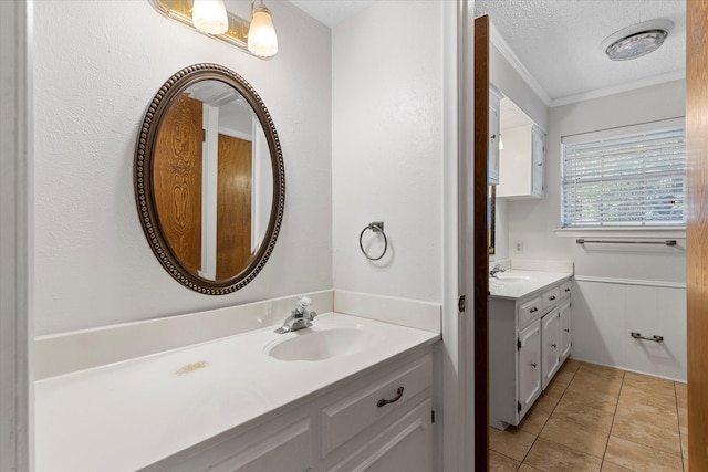 bathroom with vanity, a textured ceiling, tile patterned floors, and ornamental molding