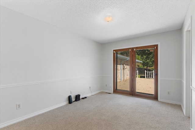 empty room featuring light colored carpet and a textured ceiling