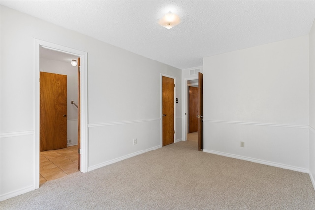 carpeted spare room featuring a textured ceiling