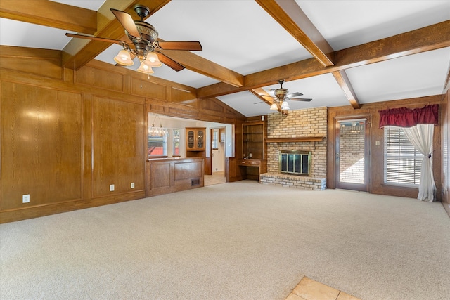 unfurnished living room featuring a brick fireplace, ceiling fan, wood walls, and light carpet