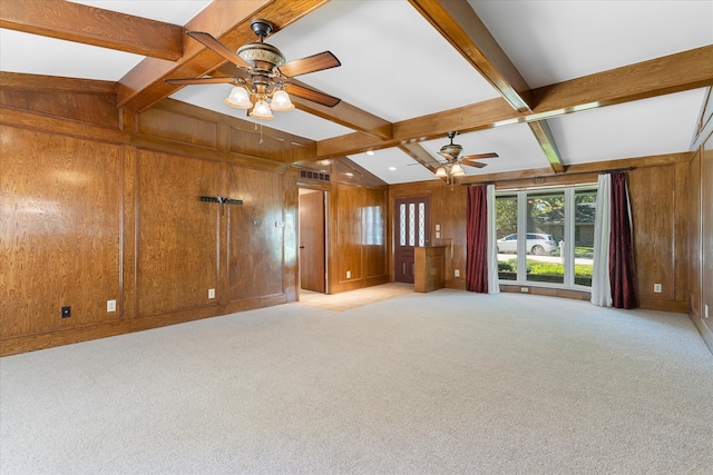 unfurnished living room with wood walls, beam ceiling, and light carpet