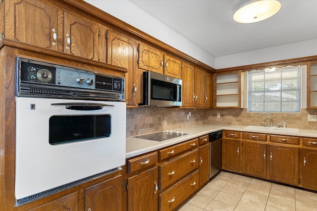 kitchen featuring light tile patterned floors, sink, decorative backsplash, and appliances with stainless steel finishes