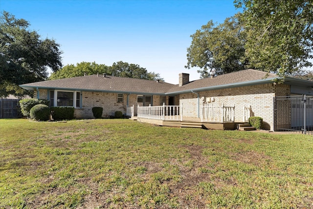 rear view of house with a wooden deck and a yard