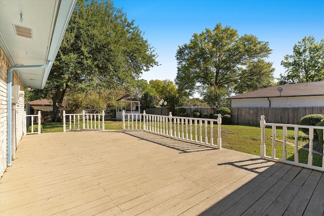 wooden deck featuring a lawn